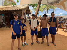 Gruppenfoto der Teilnehmer am Strand unter einem Sonnenschutz